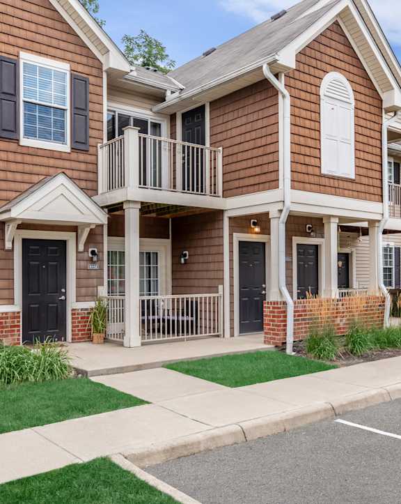 A two-story house with a balcony on the second floor.
