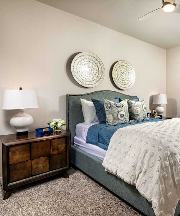 a sofa with two pillows and a side table with a lamp and a plant on it at San Carlo Townhomes, Highland California