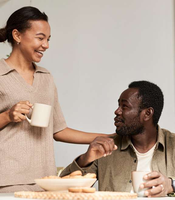 A woman serving a man a snack.