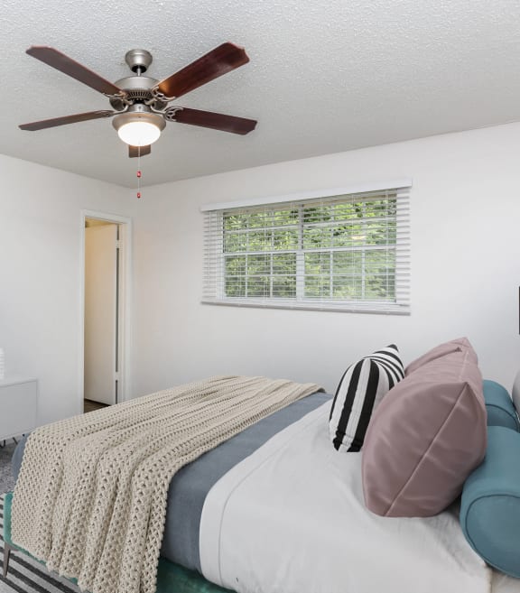 a bedroom with a bed and a ceiling fan