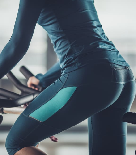 a woman riding an exercise bike in a gym at Ascend Apollo Apartments, Largo, 20774