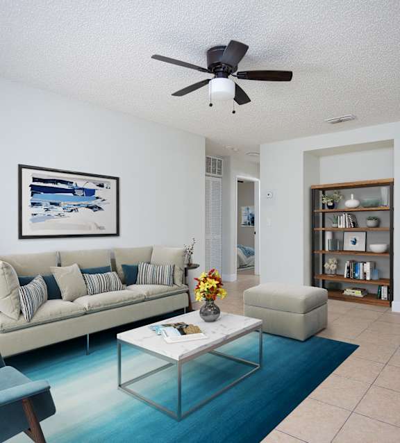 a living room with a couch and a coffee table and a ceiling fan