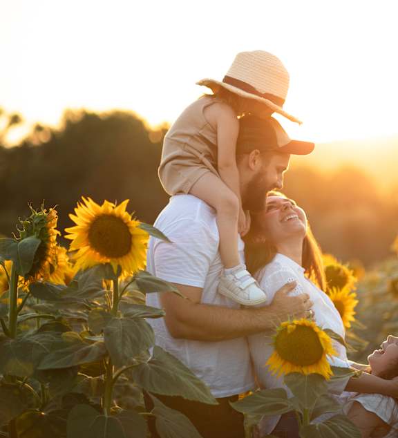 A family enjoying a sunflower field at sunset.