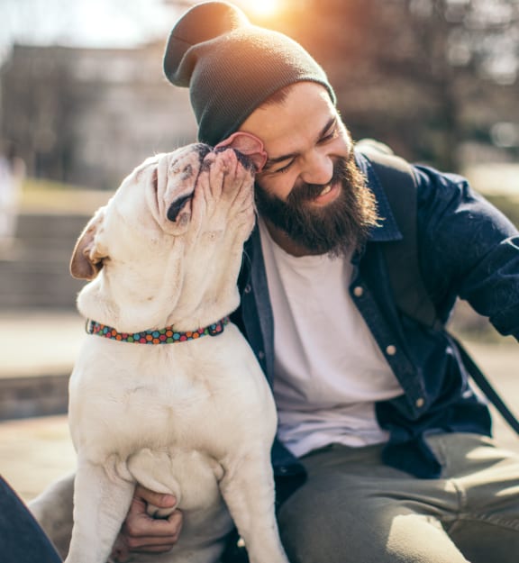 a man sitting on a bench with his dog at The Madison, Columbus, OH, 43215