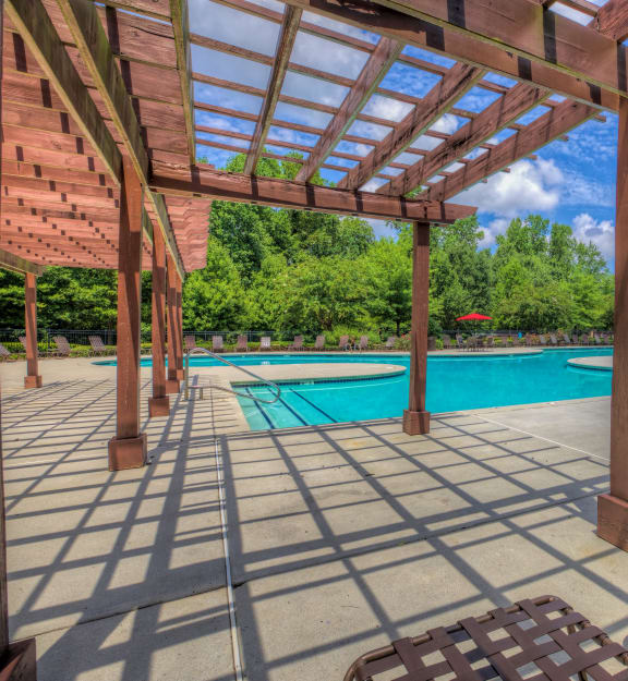 the pool is covered by a wooden pergola