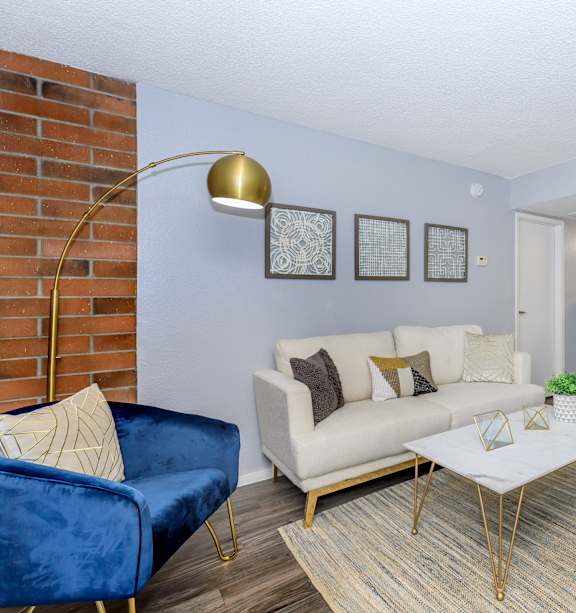 A living room with a white couch, a coffee table, and a rug.