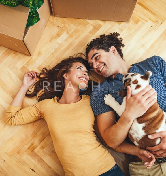 a young couple laying on the floor with a dog