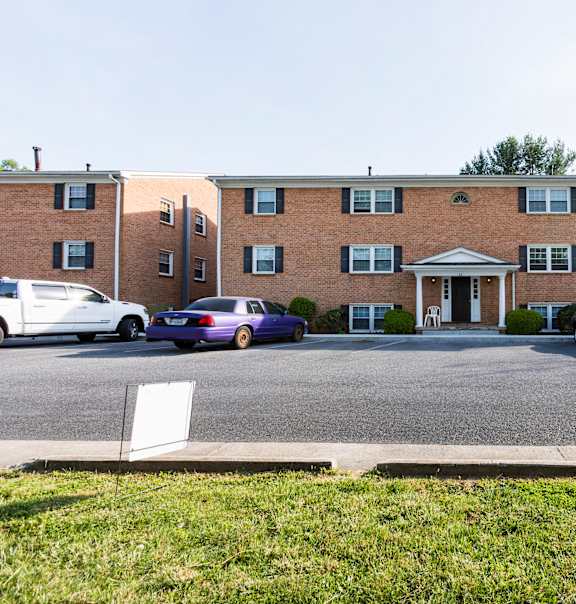 A car is parked in front of a brick building.