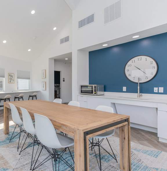 a dining room with a table and chairs and a clock on the wall