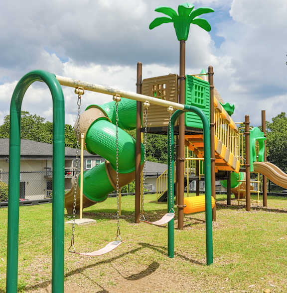 A playground with a green slide and a yellow slide.