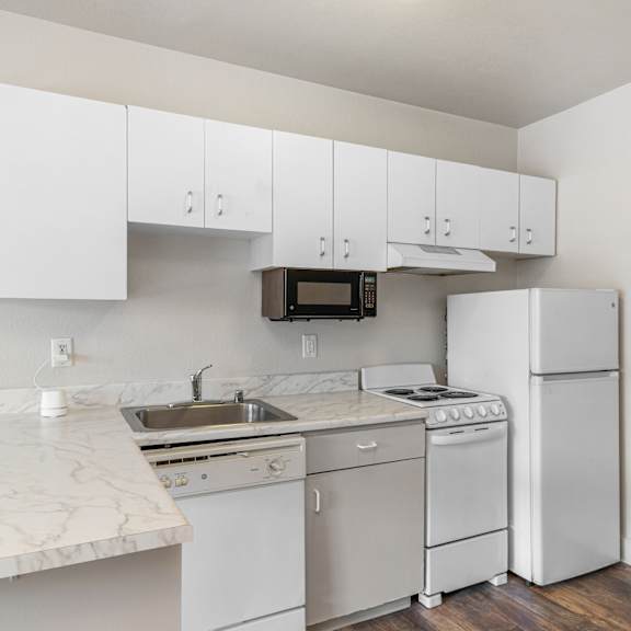 A kitchen with white appliances and cabinets.