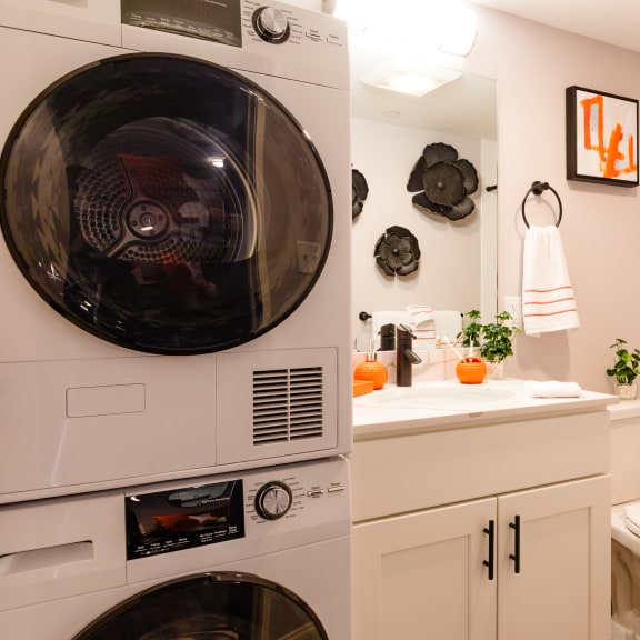 a bathroom with a toilet and a washer and dryer in it