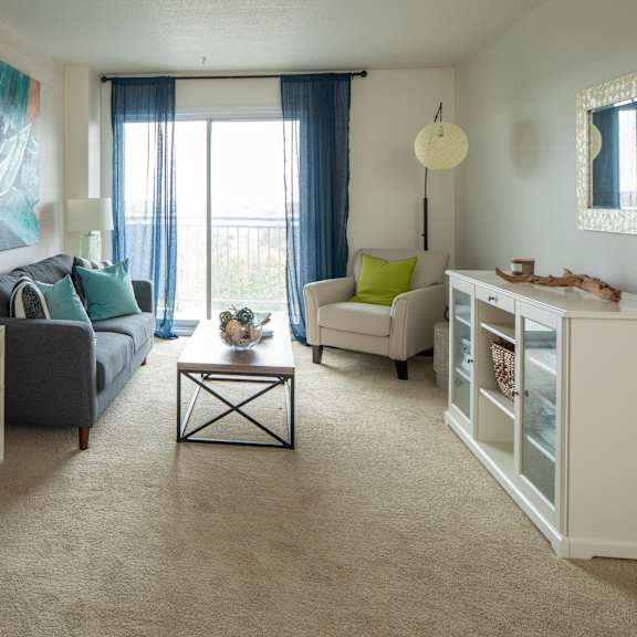 A living room with a grey couch, a round table, and a television.