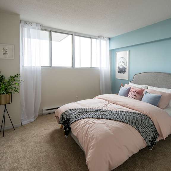 A bedroom with a large bed and a painting on the wall.
