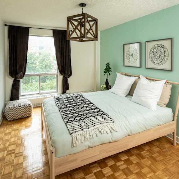 A bedroom with a large bed and a painting on the wall.