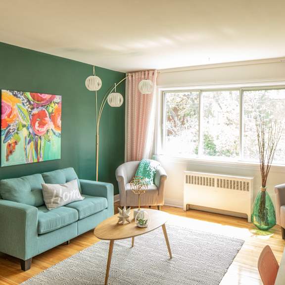 A living room with a grey couch, a round table, and a television.