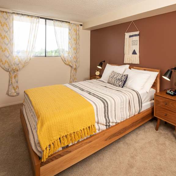A bedroom with a large bed and a painting on the wall.