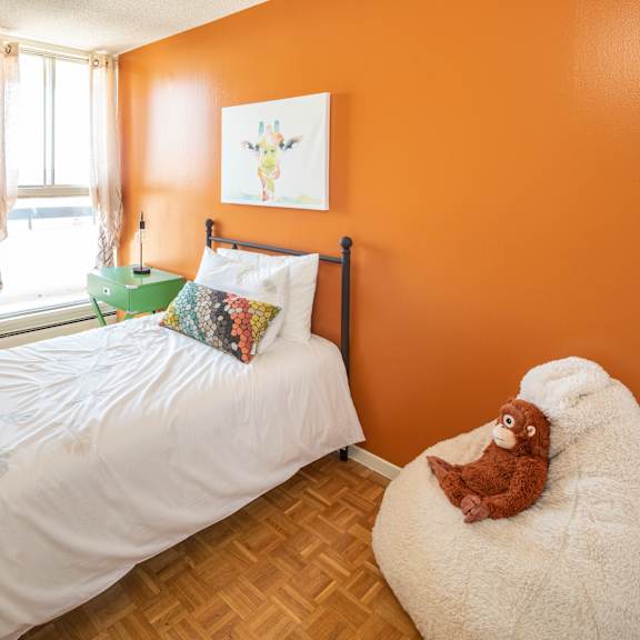 A bedroom with a large bed and a painting on the wall.