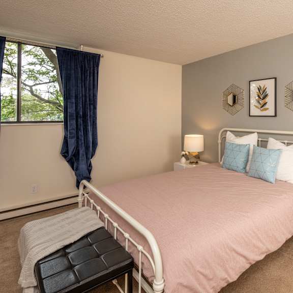 A bedroom with a large bed and a painting on the wall.