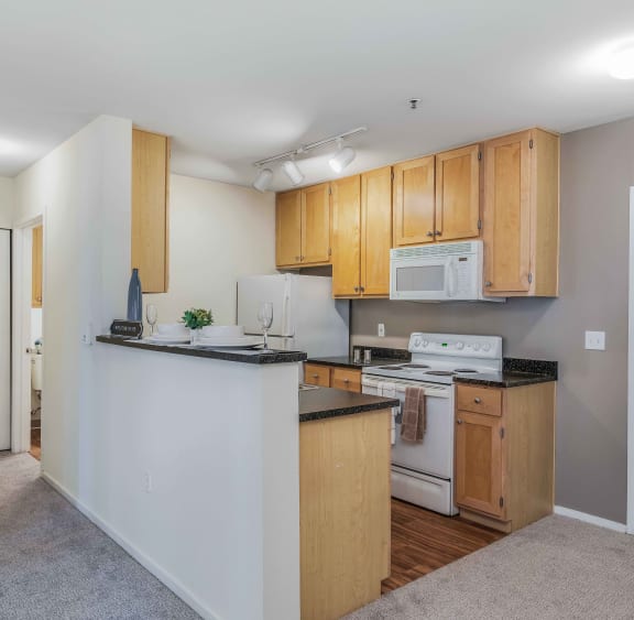 a kitchen with wood cabinets and white appliances and a counter top
