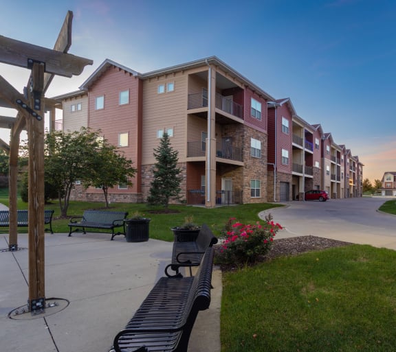 a street with benches in front of an apartment building