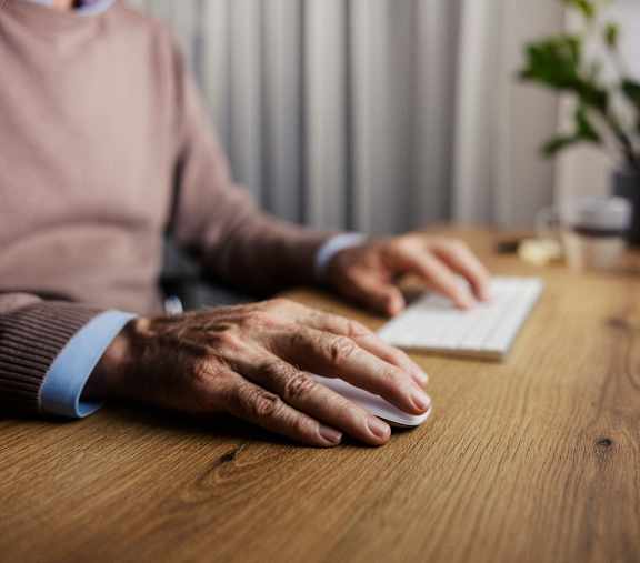 a woman typing on a laptop computer with an appointment scheduler on the screen at Humboldt Senior 55+ Apartments, Saint Paul, MN, 55107
