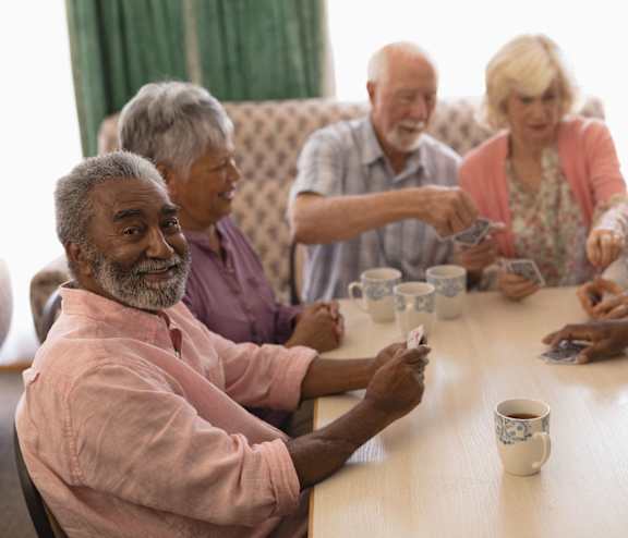a group of seniors sitting around a table playing cards