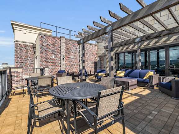 a patio with a table and chairs and a brick wall