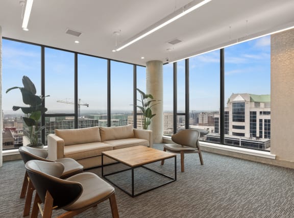 a living room with floor to ceiling windows and a view of the city