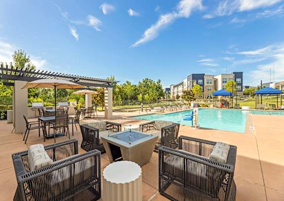 A poolside area with chairs and a table.
