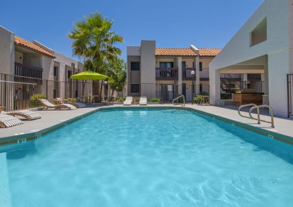 a patio with a grill and a swimming pool