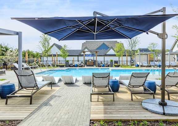 A pool area with a canopy and lounge chairs.