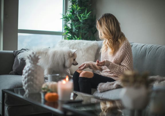 a woman sitting on a couch with her dog