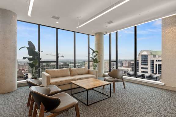 a living room with floor to ceiling windows and a view of the city