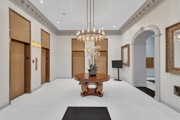 a lobby with a table and a chandelier