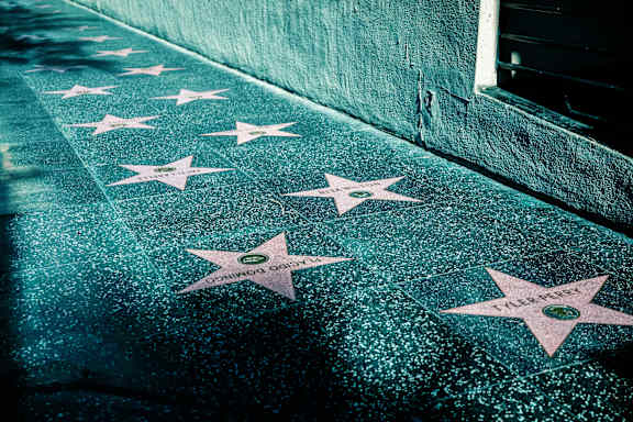 A sidewalk with white stars painted on it.