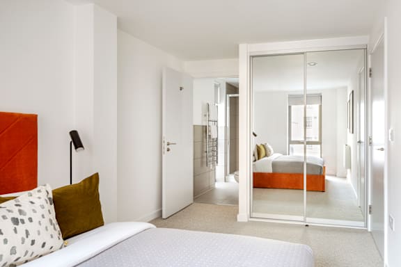 a bedroom with a bed and a mirror