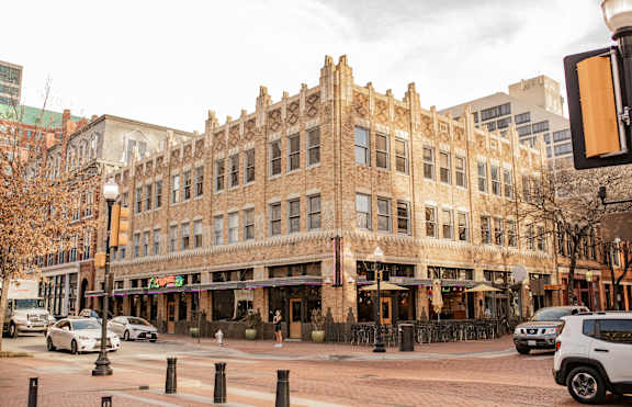 A street view of a building with cars parked in front.
