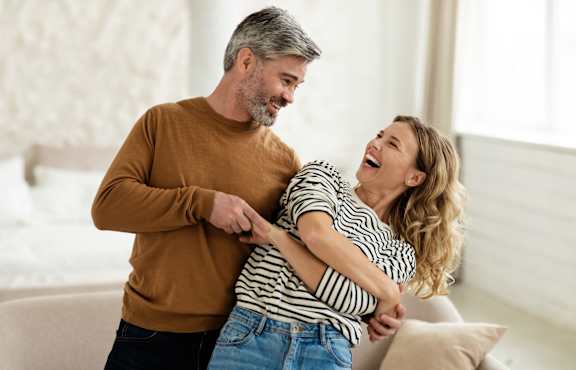 A man and a woman are dancing together in a room.