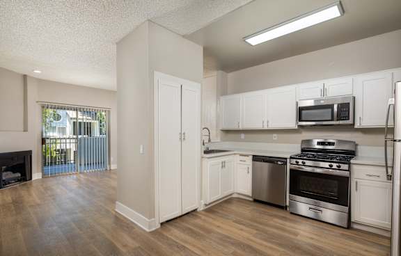 A kitchen with white cabinets and stainless steel appliances.