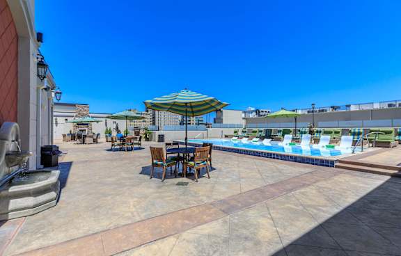 A pool area with a table and chairs under a canopy.