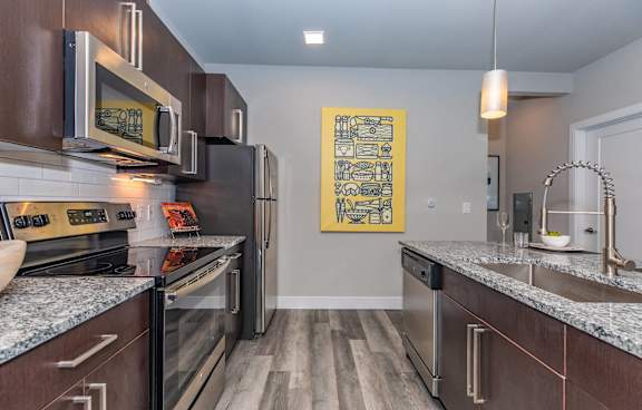 A kitchen with dark wood cabinets and stainless steel appliances.