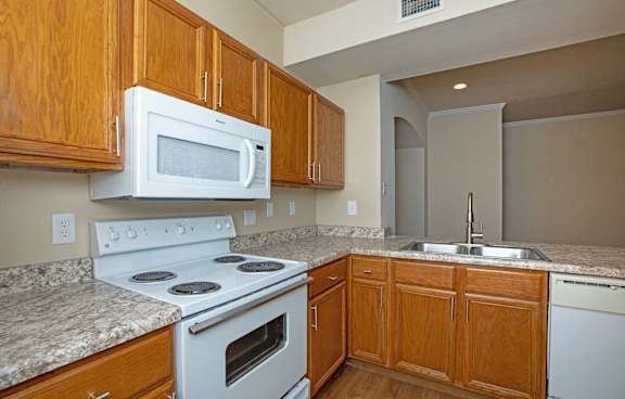 A kitchen with a white stove and microwave above a white oven.