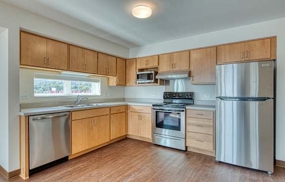 A kitchen with wooden cabinets and stainless steel appliances.