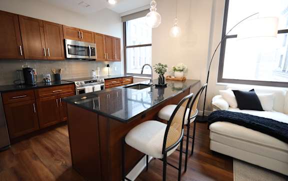 A kitchen with a black countertop and wooden cabinets.
