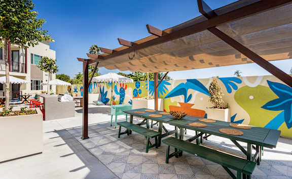 A colorful mural on a wall behind a picnic table.