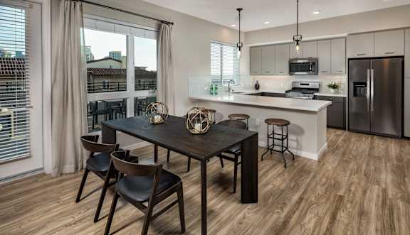 A modern kitchen with a dining table and chairs.