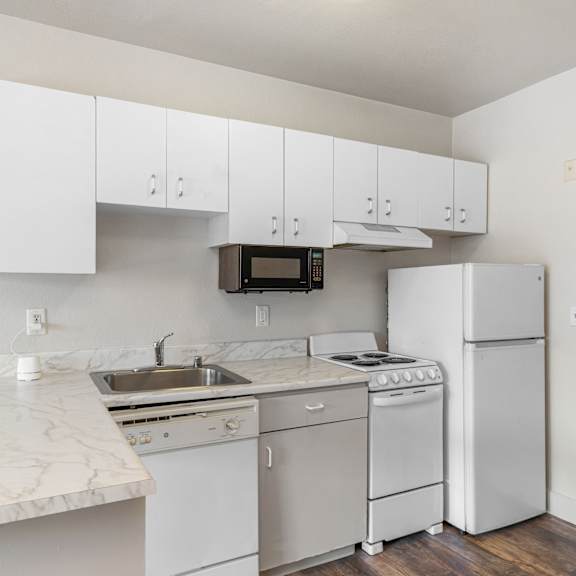 A kitchen with white appliances and cabinets.