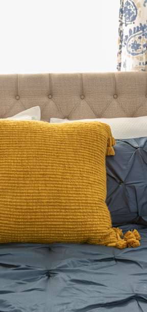 a bed with pillows and a nightstand with a lamp