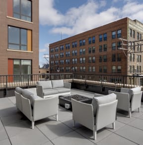 a seating area on the roof of a building with a fire pit
